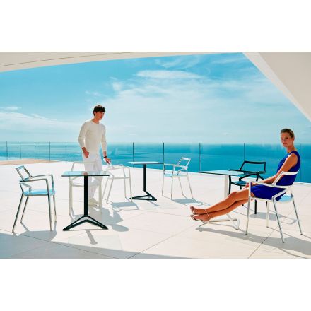 Una pareja disfrutando de las sillas Delta de VONDOM en un entorno inigualable enfrente del mar